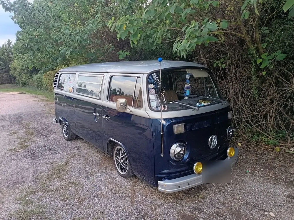 Le Combi T2 de Steeve, bleu nuit et gris, garé au bord d'un chemin